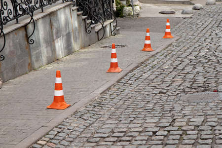 Traffic cone stay on paving stone street. Limit for parking.