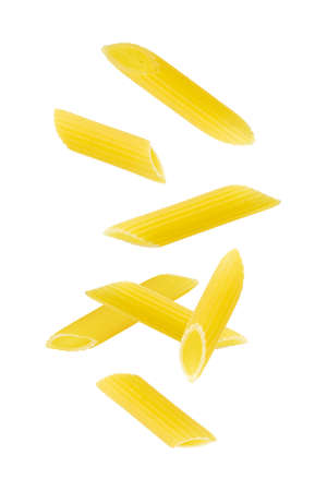 Falling penne pasta. Flying yellow raw macaroni over white background.の写真素材
