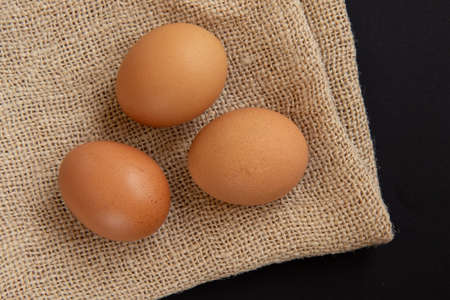 Fresh chicken eggs on burlap sack. Top view, flat lay.の写真素材