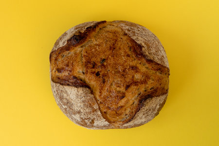 Delicious homemade sourdough bread, isolated on yellow background, top view. Apulian bread.の写真素材