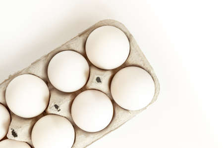 White chicken eggs in box. Cardboard egg box with chicken eggs on white background.