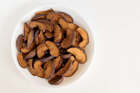 Homemade sun-dried organic apple slices on white background, crispy apple chips. Flat lay.