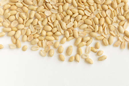 Arranged peanuts peeled and isolated on white background. Top view, close-up.
