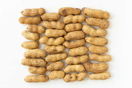 Unshelled peanuts background isolated on white background top view.