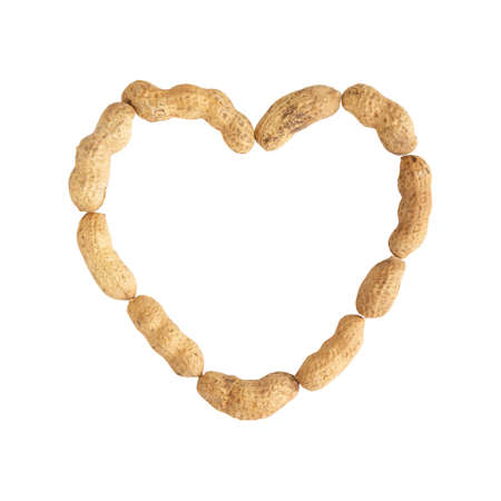 Peanut made in heart shape on white background. Top view. Flat lay. Valentine's day. Symbol of...