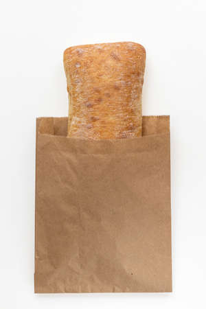 Newly baked Italian ciabatta bread from wheat flour in package on white background. Top view flat layの写真素材