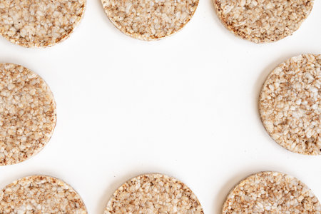 crunchy rice cakes isolated on white background, frame of puffed whole grain crispbread and empty...