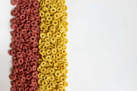 delicious cheerios oat cereal in large pile, cereal cheerios background, delicious and useful breakfast, frame with colored rings breakfast cereal and empty space for textの写真素材