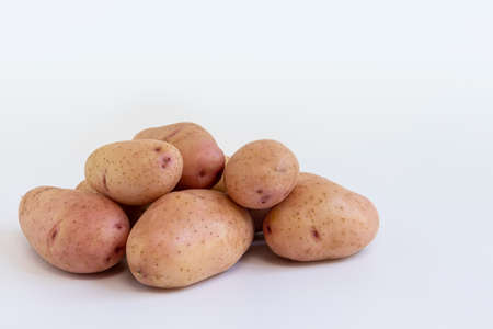 pile of fresh raw potatoes isolated on white background, raw vegetables, harvest new of red potatoes, side viewの写真素材