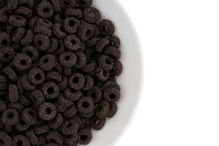 heap of black cereal rings isolated on white background, delicious and useful rings breakfast cereal in bowl, top view closeupの写真素材