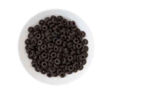 heap of black cereal rings isolated on white background, delicious and useful rings breakfast cereal in bowl, top viewの写真素材