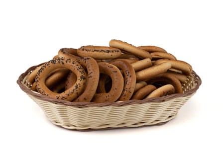 bagels with poppy in breadbasket isolated on white background, side view, food market bakery concept