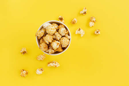 caramel popcorn in bowl on yellow with copy space for text, close up, sweet snacks, caramel popcorn for watching movies, top viewの写真素材
