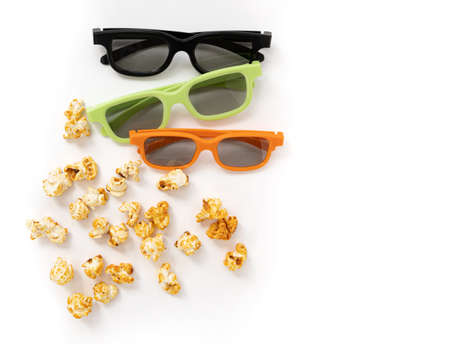 heap of caramel popcorn and 3D glasses on white background with copy space, home cinema, top view