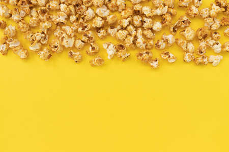 frame of caramel popcorn and empty space for text on yellow background, sweet snacksの写真素材