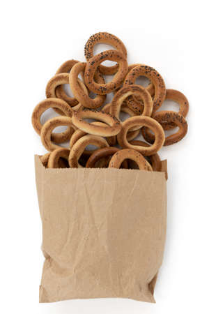 pile of bagels with poppy seeds in small paper bag isolated on white background, top view, food bakery conceptの写真素材