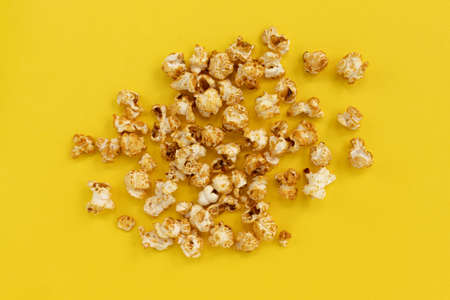 frame of caramel popcorn and empty space for text on yellow background, sweet snacksの写真素材