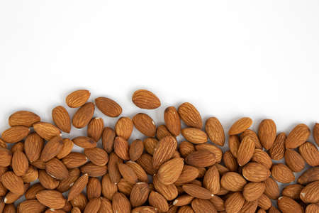 frame of peeled almond nuts with copy space for text isolated on white background, healthy snacks, close upの写真素材