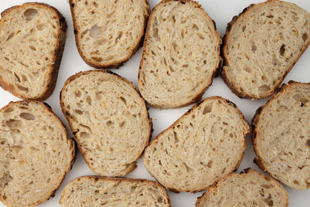 top view of tasty whole grain bread slices on white background, fresh rustic bread with onions