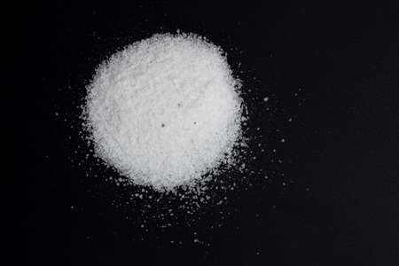 pile of kitchen salt, mineral sea salt isolated on black background
