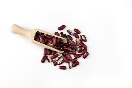 red kidney beans in wooden scoop isolated on white background close up, top viewの写真素材
