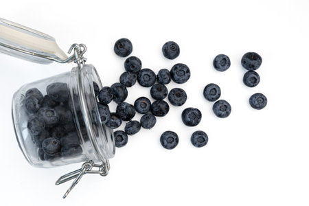 fresh blueberries in glass jar isolated on white background, raw berries used in cooking, cosmetics and medicine, close upの写真素材