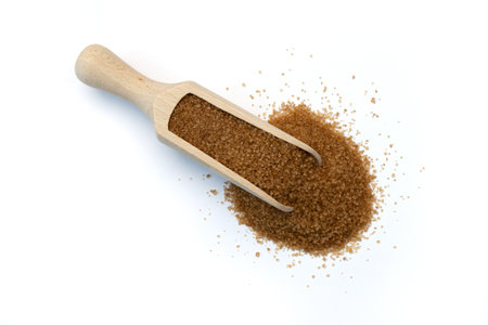 wooden scoop with brown sugar isolated on white background, unrefined natural cane sugar, top viewの写真素材