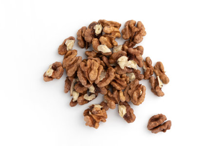heap of roasted nuts isolated on white background, walnuts close-up, snack food concept, vegan mealの写真素材
