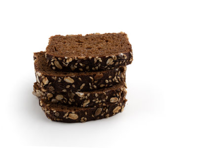 slices of rye bread on white background, side view, heap of fresh delicious homemade healthy bakingの写真素材