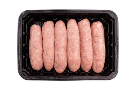 uncooked pork sausages in plastic food packaging isolated on white backgroundの写真素材