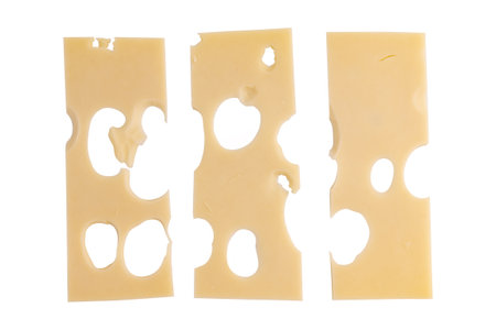 maasdam cheese slices with holes closeup, swiss cheese isolated on white background, top viewの写真素材