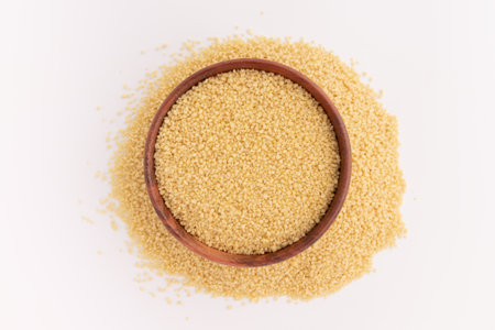 dry couscous in wooden bowl isolated on white background with clipping pathの写真素材