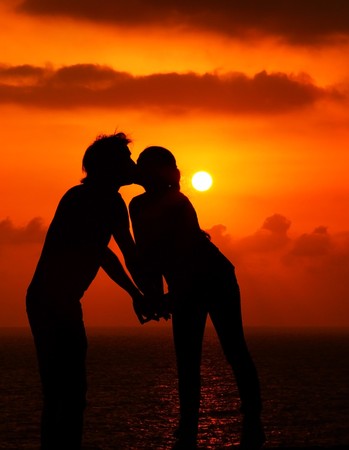 Happy couple romantically kissing at warm summer eveningの写真素材