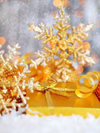 Winter holiday background with golden present gift box, Christmas tree snowflake ornament  & defocus lights decorationの写真素材