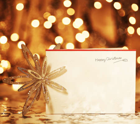 Beautiful gold happy Christmas card,winter holiday background, decoration postcard with snowflakes abstract over defocus lightsの写真素材