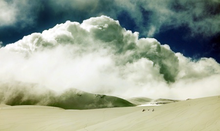 Grunge winter landscape of high mountains with snow blizzard and fresh blue sky, beautiful nature...