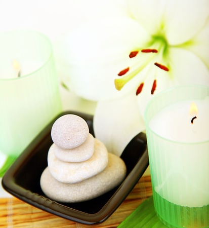 Candles and balanced zen spa stones with lily flower, relaxation vacation conceptの写真素材