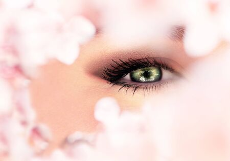 Beautiful abstract green eye surrounded with flowersの写真素材