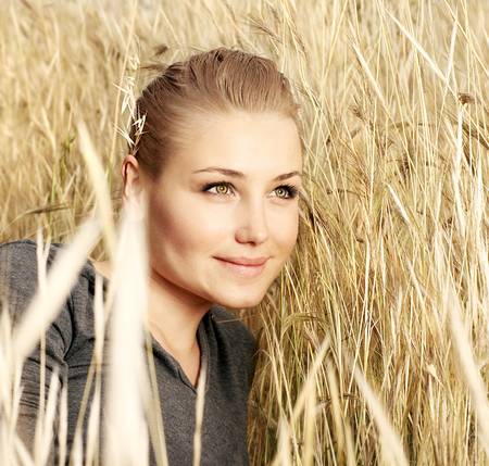 Young beautiful girl laying in the wheat field, outdoor portrait, summer fun conceptの写真素材
