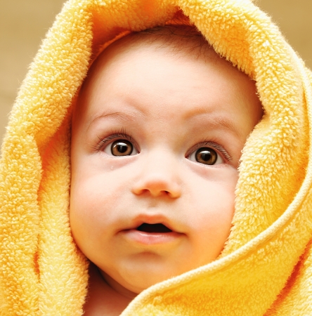 Cute baby face wrapped in towel, hygiene and health care conceptの写真素材