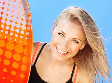 Happy young surfer portrait over blue sky, vacation and summertime activities, beautiful female smiling, outdoor funの写真素材