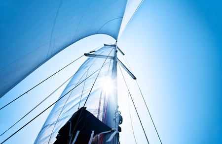 Sail over clear blue sky, sailboat over natural background with sunlight, summertime activities and extreme sport Sail over clear blue sky, sailboat over natural background with sunlight, summertime activities and extreme sport