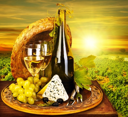 Wine and cheese romantic dinner outdoor, table for two with vineyard view, fresh grapes and wineglass at restaurant, warm autumn sunset, grape field landscape at harvest, food still life Wine and cheese romantic dinner outdoor, table for two with vineyard view, fresh grapes and wineglass at restaurant, warm autumn sunset, grape field landscape at harvest, food still life