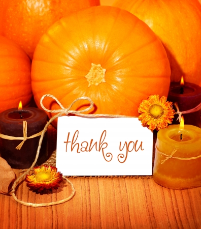 Thank you orange background, thanksgiving greeting card with pumpkin decorations and warm candle light, holiday still life with white copy spaceの写真素材