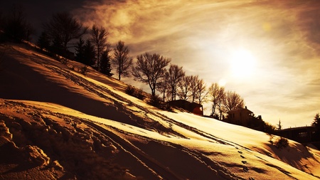 Winter sunset, beautiful mountains landscape, village covered with snow, cold weather wintertime seasonal nature, dramatic sky with warm sun lightの写真素材