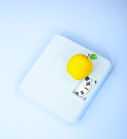 Scales and apple, body weight watching, conceptual image of dieting, calorie count, healthy lifestyle and shape controlの写真素材