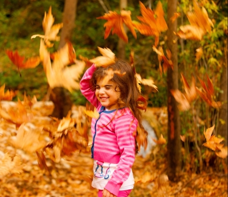 a little cute girl playing in autumn park, adorable sweet kid throwing up old dry foliage, cheerful small female child playing outdoors, nice toddler laughing with closed eyes
の写真素材