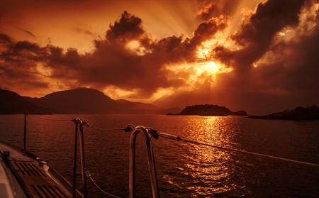Yacht deck on red dramatic sunset, peaceful seascape, marine adventure, summer holiday, yachting sport, freedom and recreation conceptの写真素材