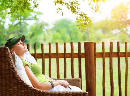 Cute girl resting on veranda, young traveler woman sleeping on backyard in sanatorium, relaxation outdoors, luxury resort, pleasure concept