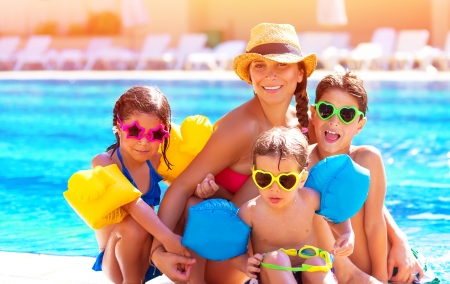 Happy big family having fun at the pool, spending summer vacation together, wearing funny colorful sunglasses, enjoyment and pleasure concept